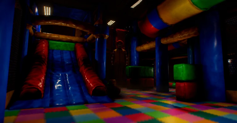 A dark indoor soft-play centre: an inflatable slide, padded blocks in primary colours and a patterned play mat, with a clown-like figure standing in the middle distance.